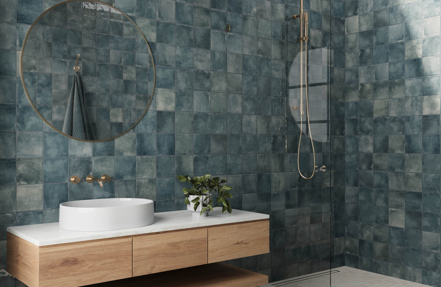 Soft matte, blue-green square tiles cover the bathroom walls, creating a serene, spa-like ambiance complemented by a minimalist round mirror and sleek wooden vanity.
