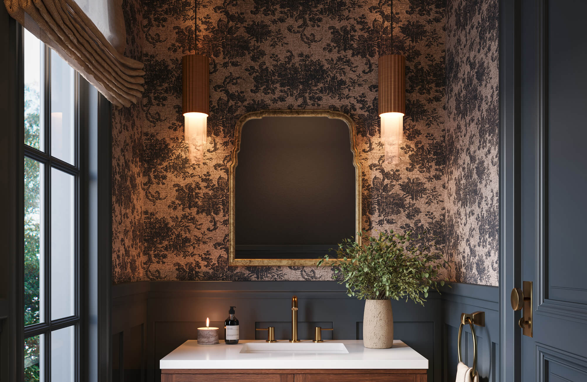 Moody powder room with dark floral wallpaper, deep blue wainscoting, vanity, warm brass fixtures, and a vintage-inspired framed mirror.