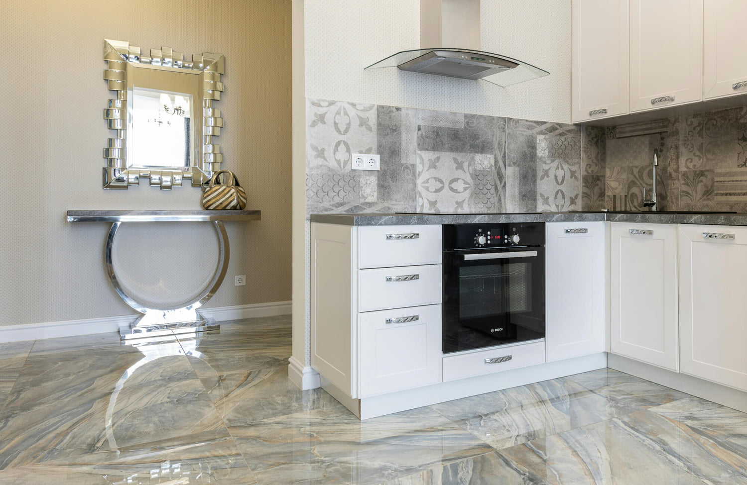 Luxurious kitchen with glossy marble-look flooring and patterned gray backsplash tiles, complementing the sleek white cabinetry