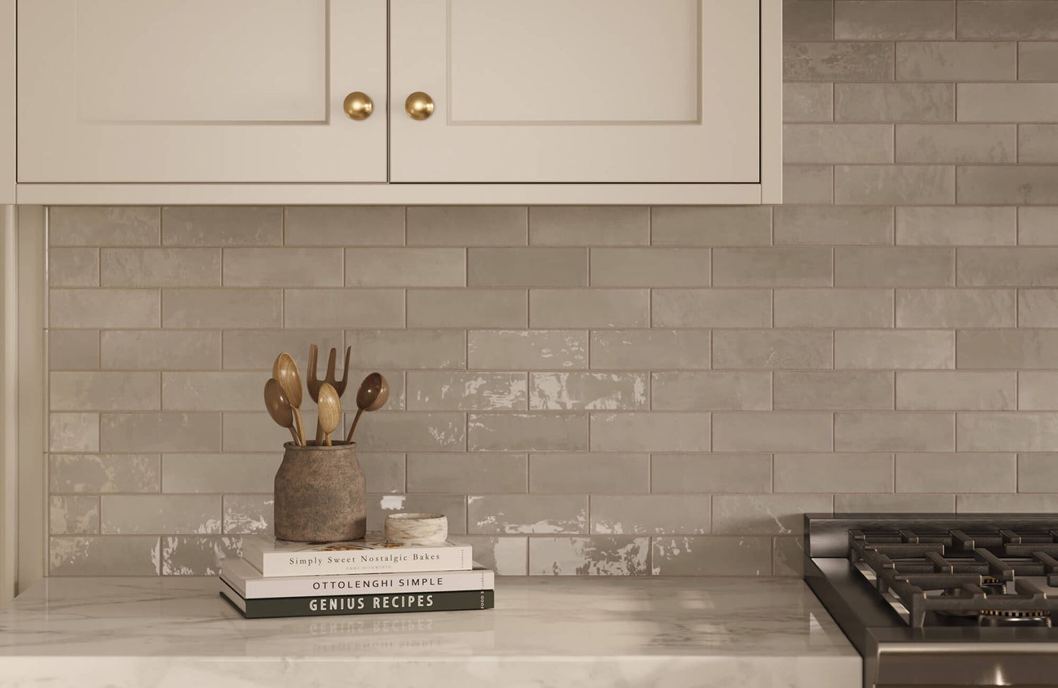 Glossy gray subway tiles in a staggered layout add subtle texture and warmth to a neutral kitchen backsplash.