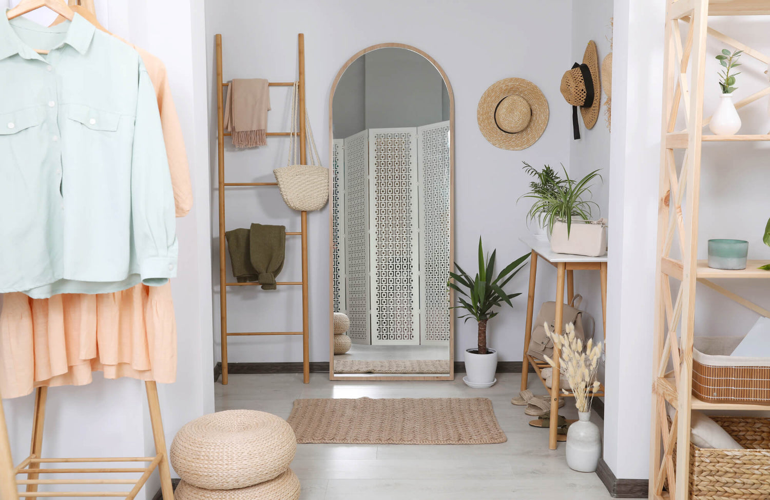 Bright, stylish entryway with a tall arched mirror, woven accents, plants, and light wood furniture creating a cozy, natural aesthetic.