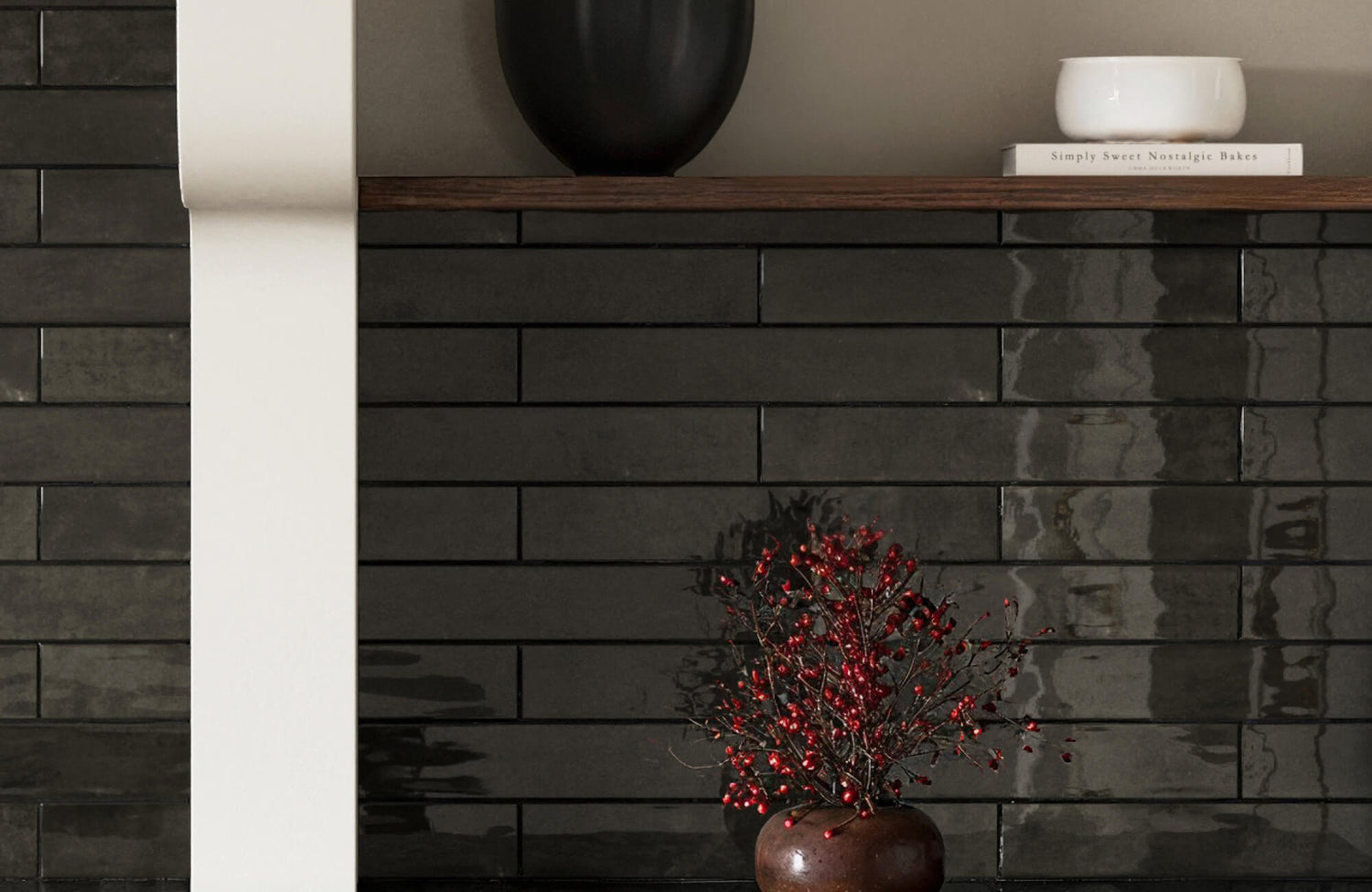 Sleek charcoal brick tiles with a rich matte-gloss finish, styled with minimal decor and a red berry arrangement.