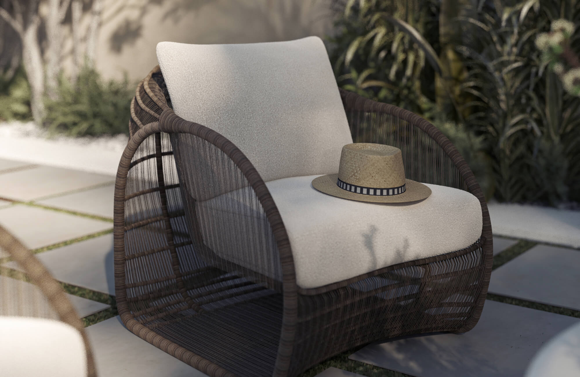 Resting on a woven outdoor chair, a cream cushion softens the seat while a straw hat adds a relaxed touch, highlighting how cushions improve comfort in outdoor furniture.