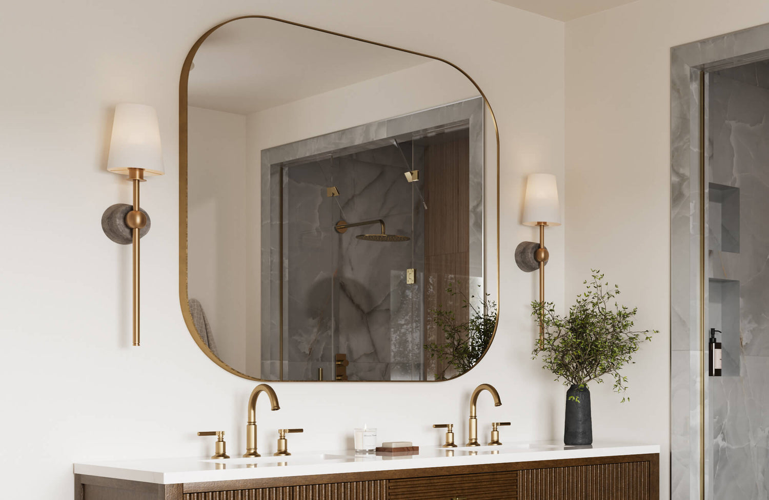 Elegant bathroom vanity with gold-framed mirror, marble shower tiles, and brushed brass fixtures paired with modern wall sconces