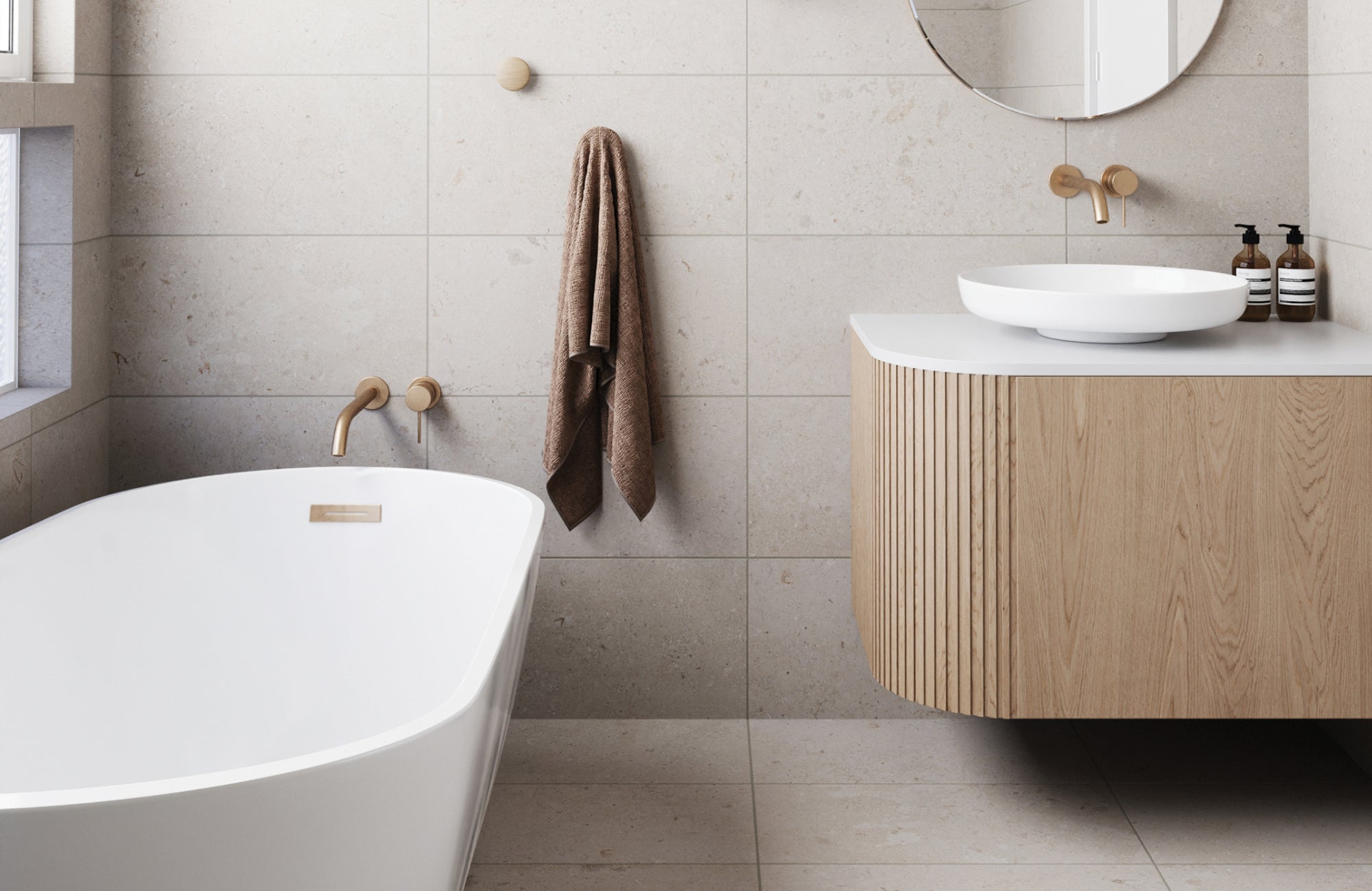 Modern bathroom with freestanding tub and beige large bathroom tiles on walls and floors for a soft, natural look