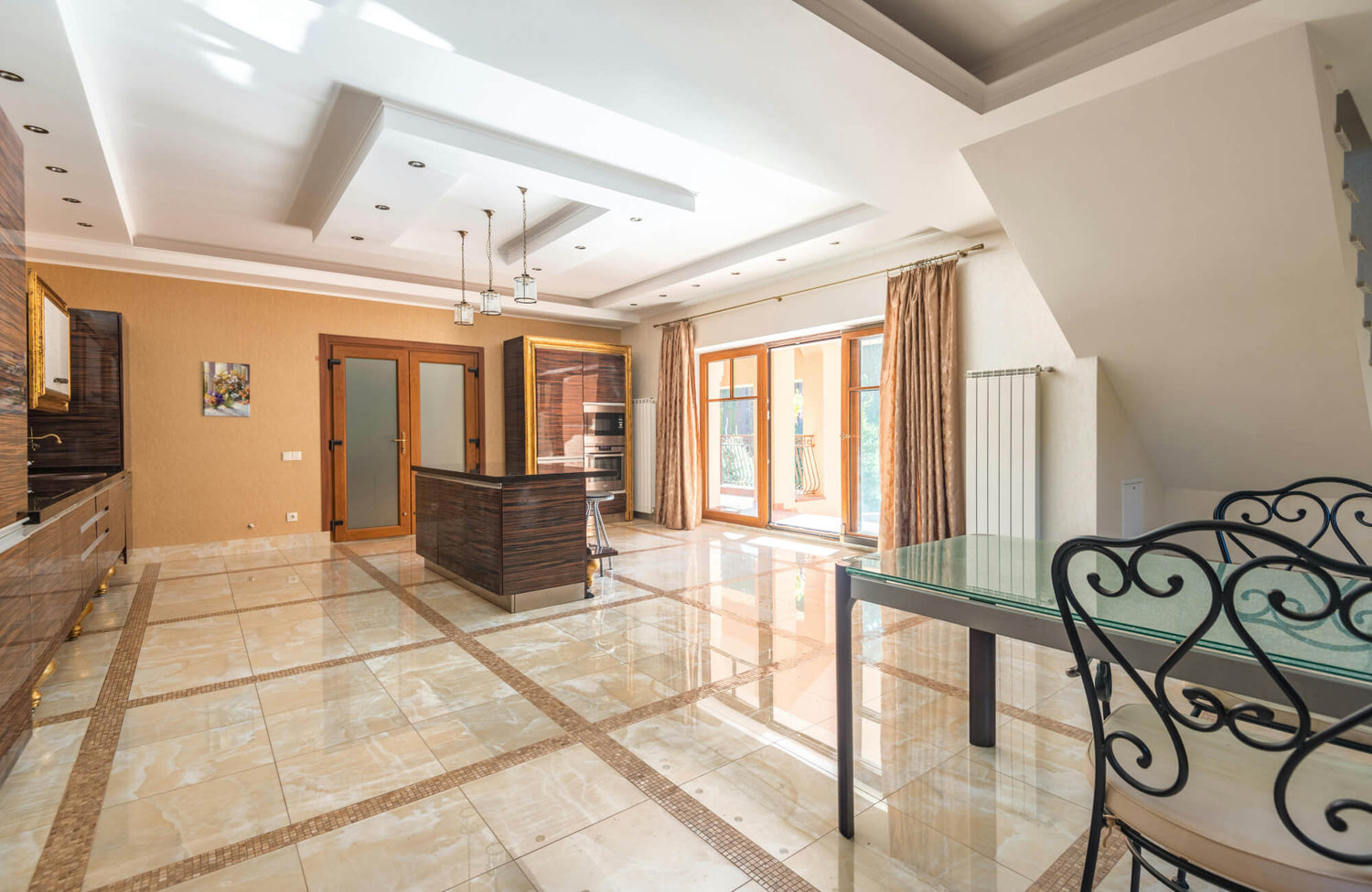 Elegant open kitchen and dining area with polished marble tile flooring in a grid pattern, blending luxury with everyday durability.