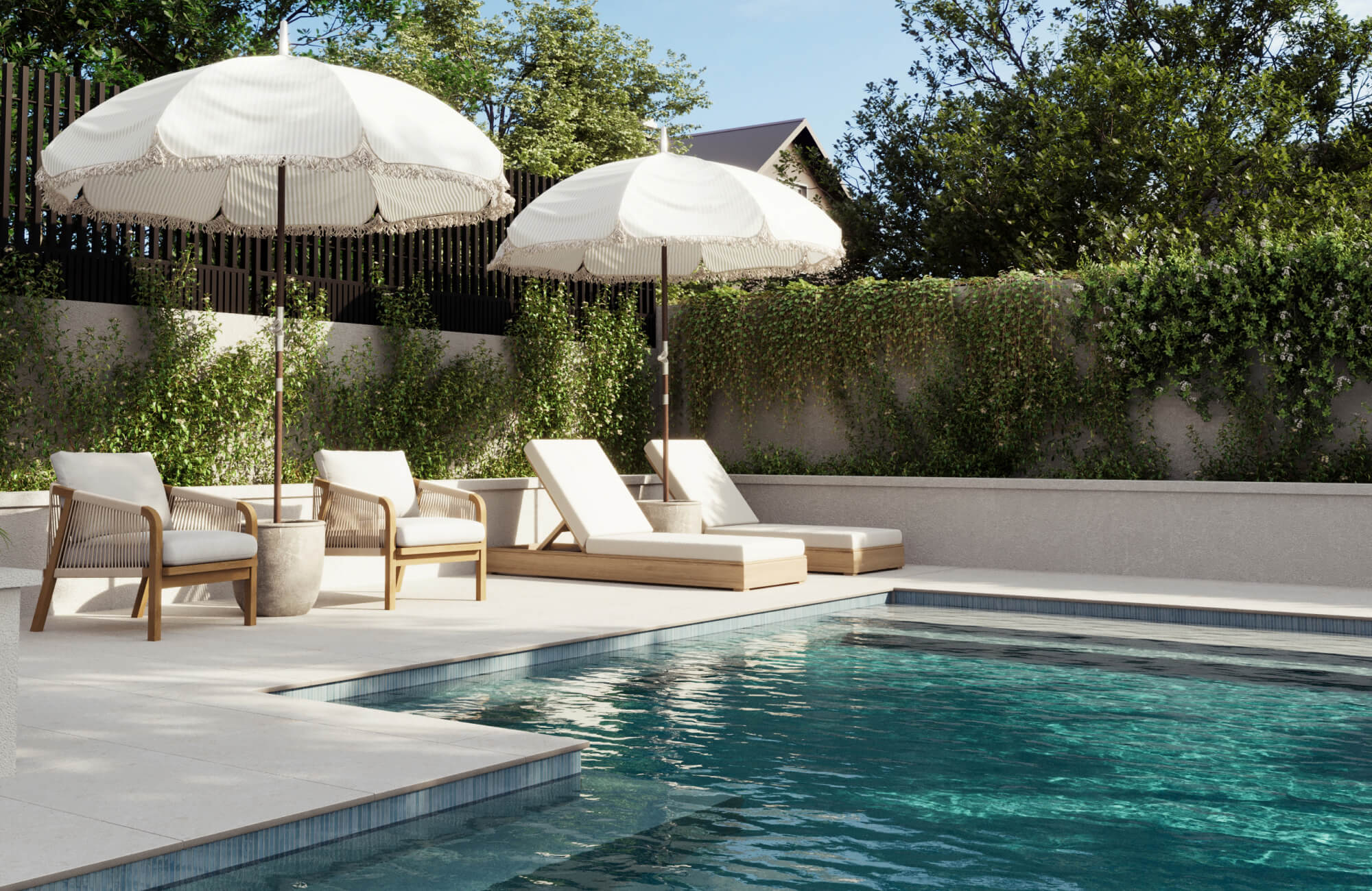 Modern pool deck featuring creamy porcelain paver tiles with wood-framed loungers, fringed umbrellas, and lush vine-covered walls