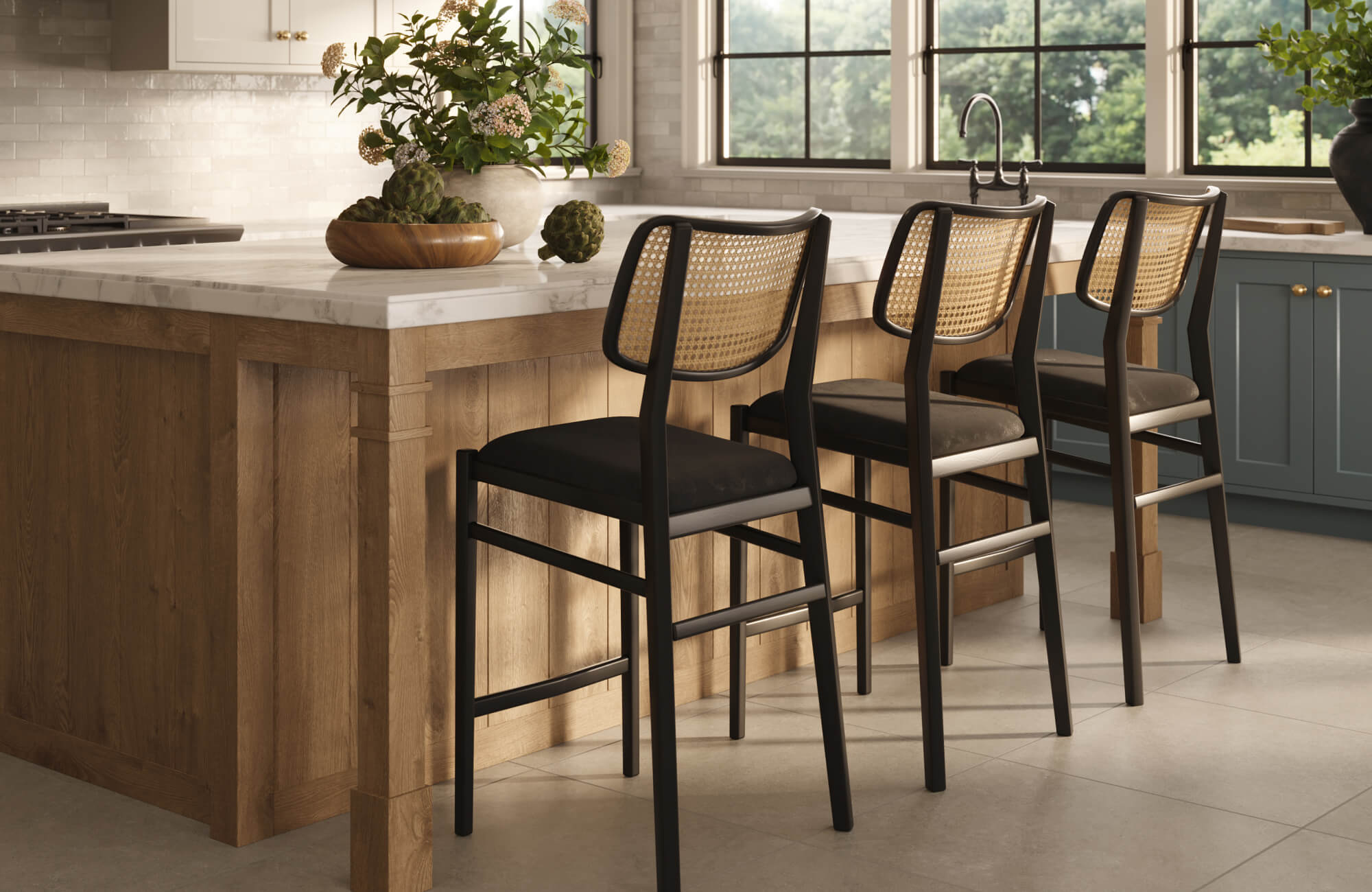 Warm kitchen island with marble countertop, wood paneling, and black bar stools featuring a woven rattan back and cushioned seats.