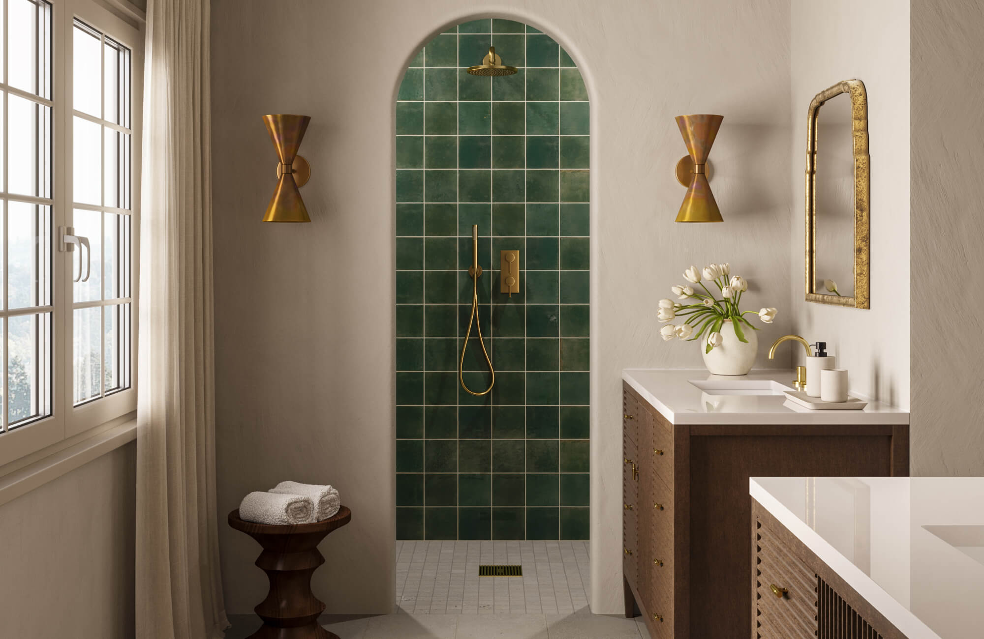 Elegant bathroom with arched shower of green traditional tiles, gold fixtures, and brass sconces.