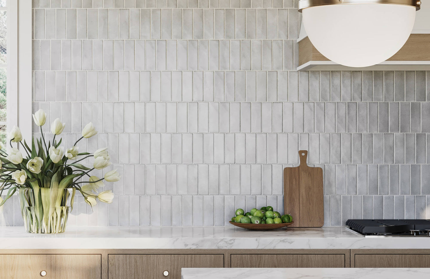 Vertical glossy porcelain subway tiles in soft gray tones offer a sleek, reflective finish with a contemporary vertical layout