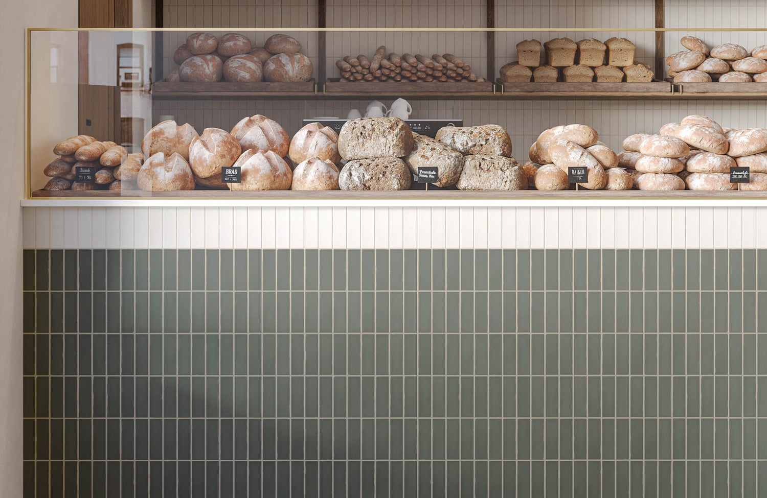Bakery counter with stacked bread loaves, featuring vertical two-tone subway tile cladding in cream and olive green.
