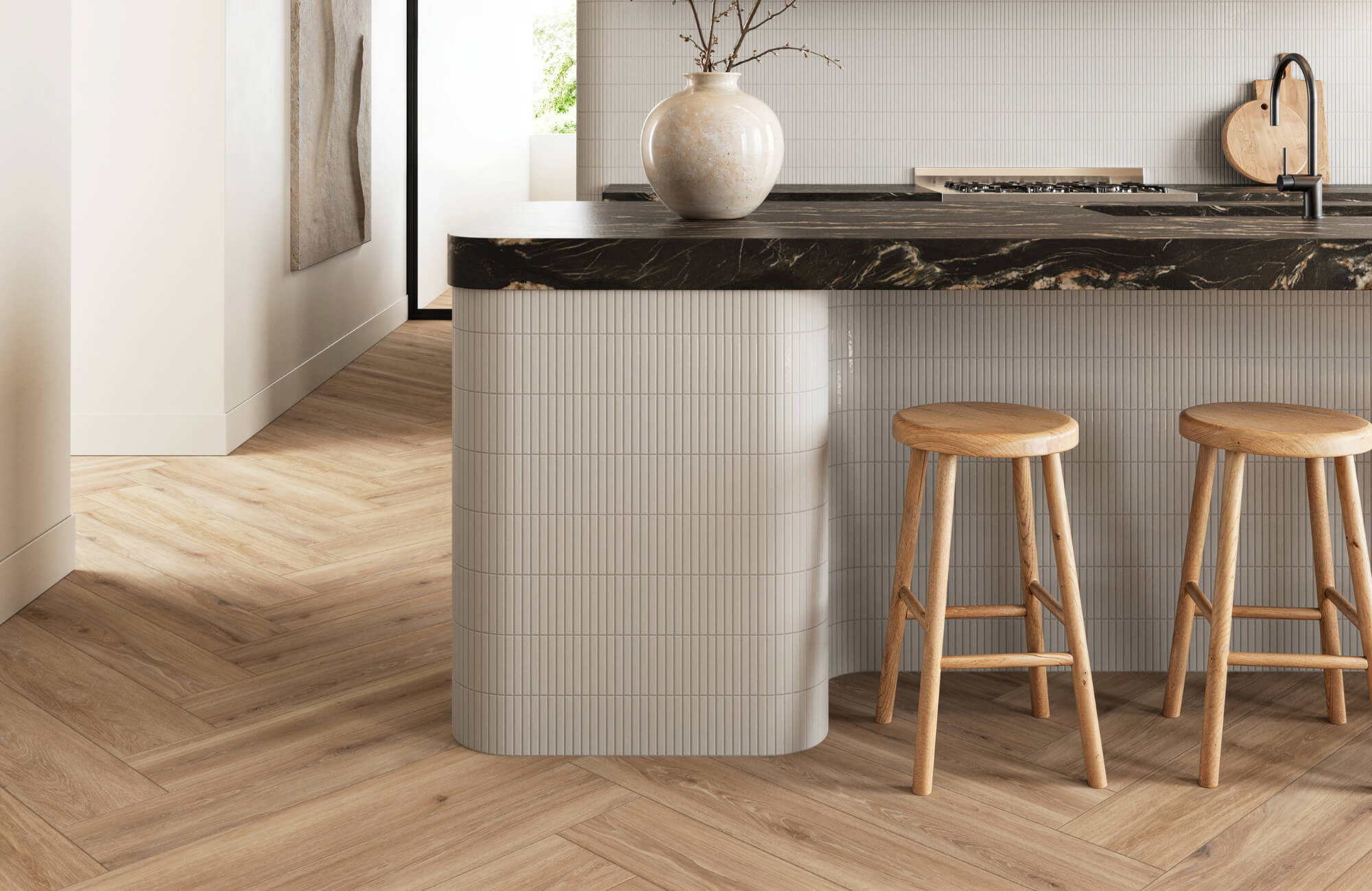 Modern kitchen featuring herringbone wood look tile flooring, rounded white backsplash island, black marble countertop, and wooden stools.