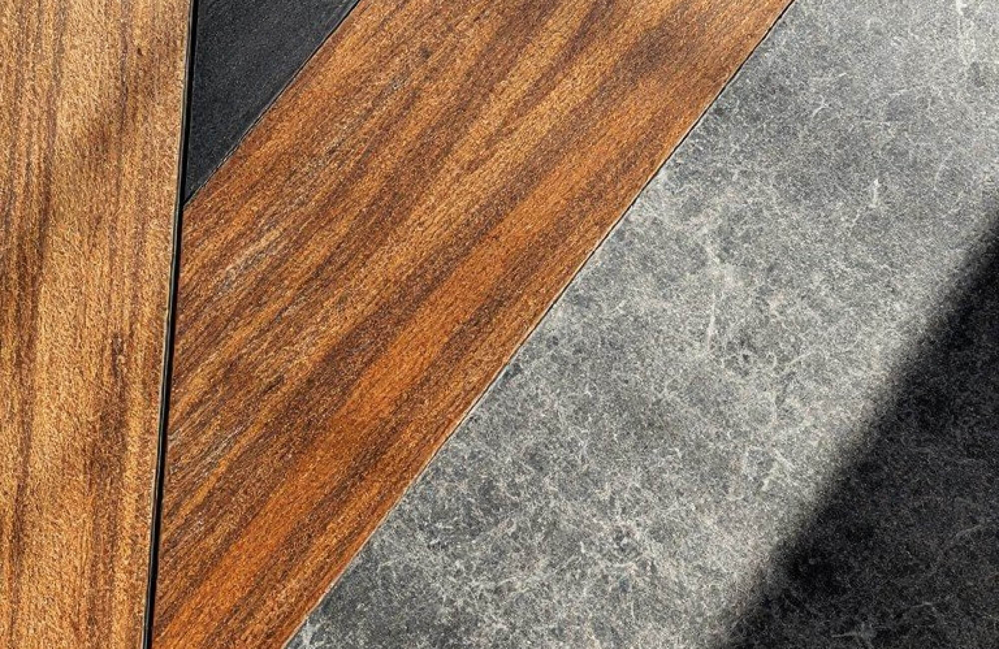 Wood-look tile plank beside textured concrete tile, highlighting contrasting flooring styles used in modern interior design.