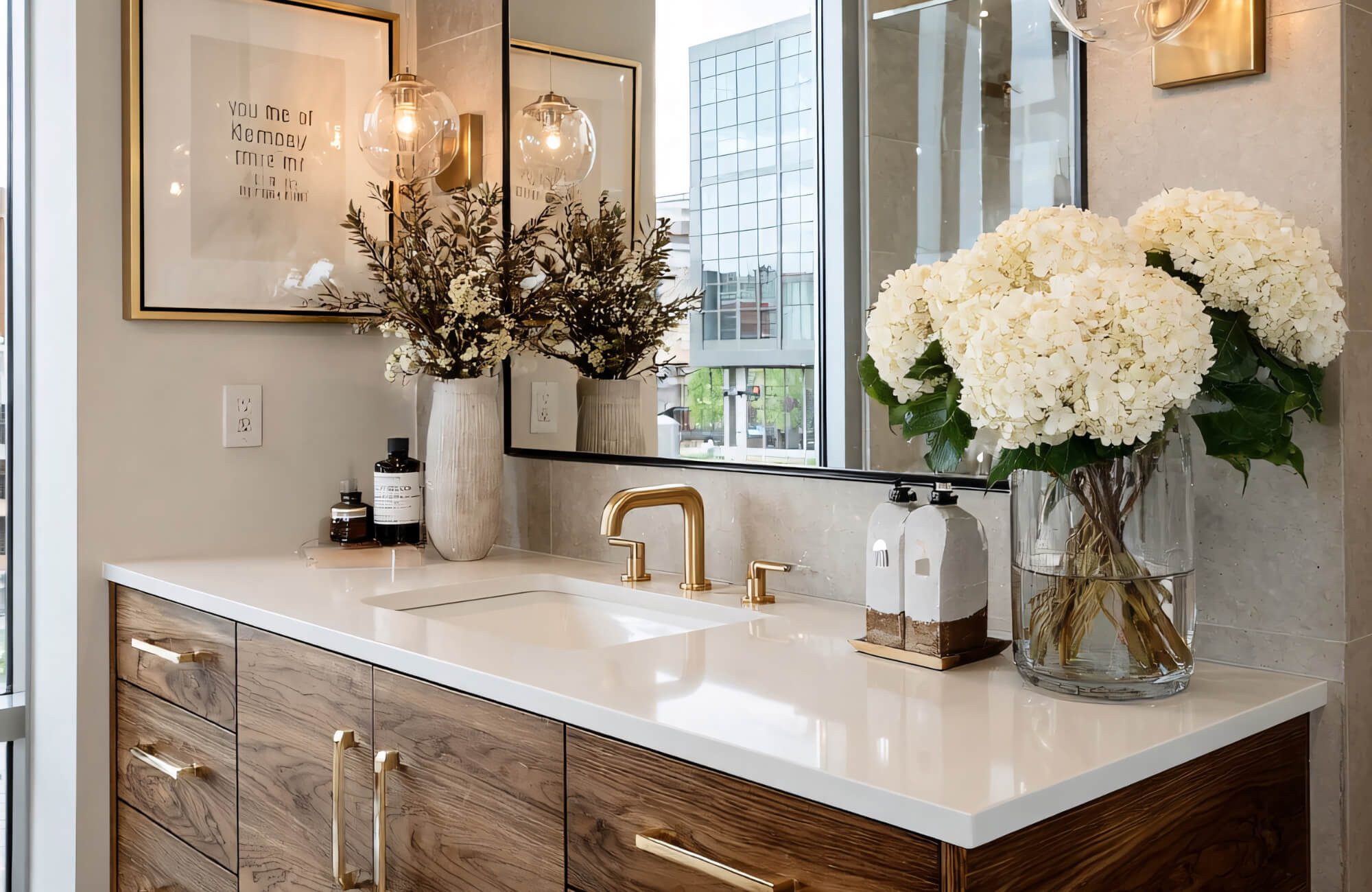 Modern bathroom vanity with integrated mirror lighting, brass fixtures, and styled countertop creating a polished, camera-ready workspace.