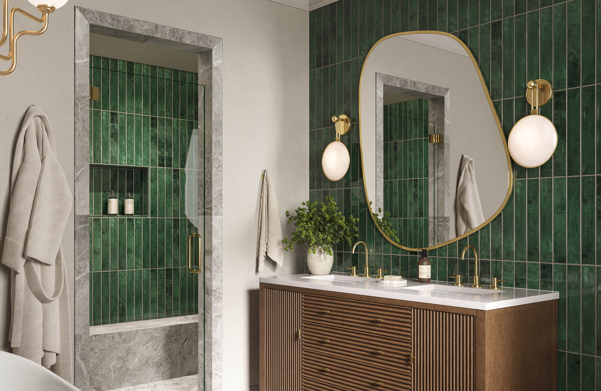 Luxurious bathroom with rich emerald green vertical tiles, organic mirror, gold accents, and a sleek wooden vanity topped with a white countertop.
