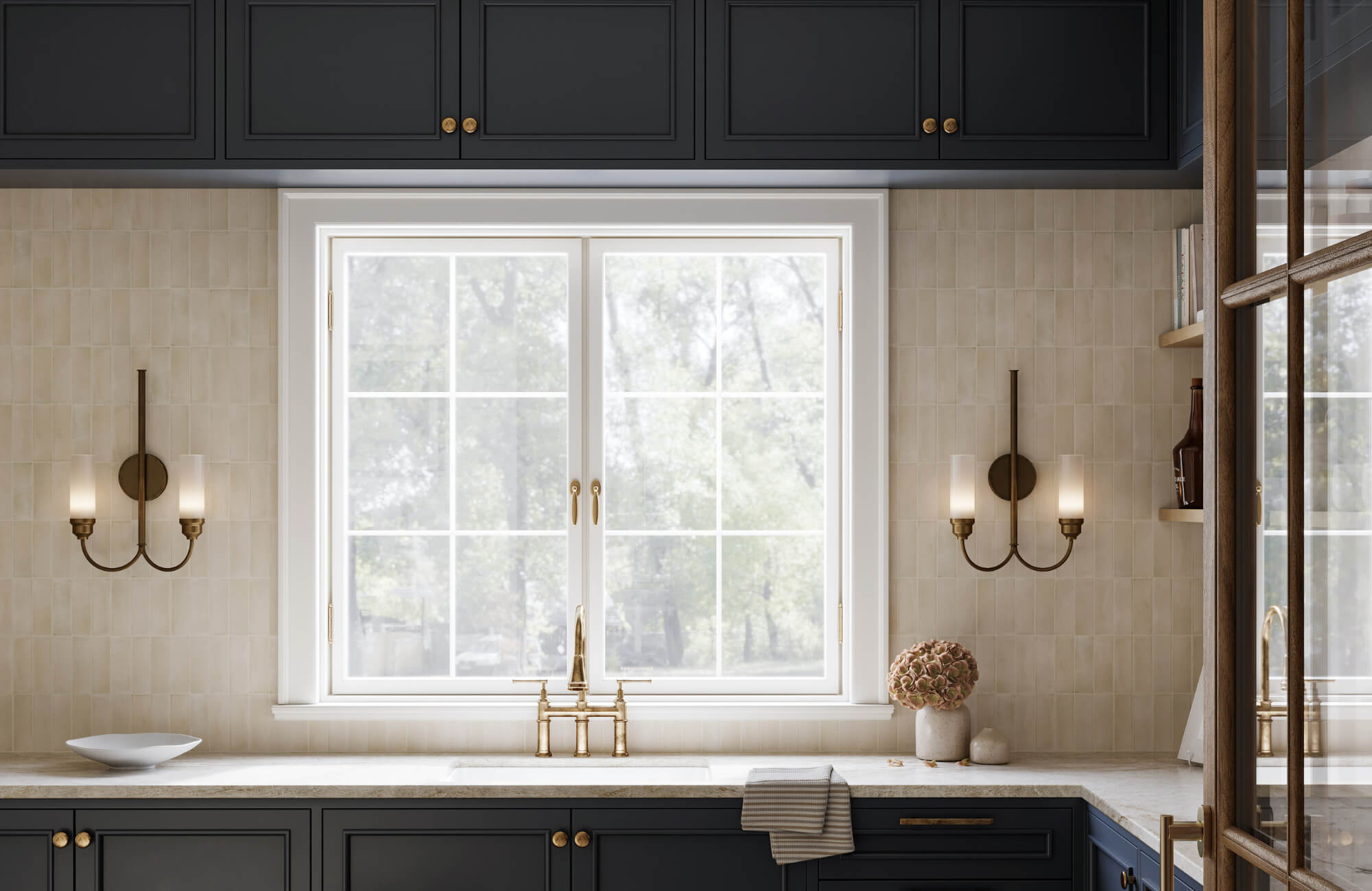 Modern kitchen with black cabinetry, brass fixtures, and dual brass sconces flanking a large window above a marble countertop.
