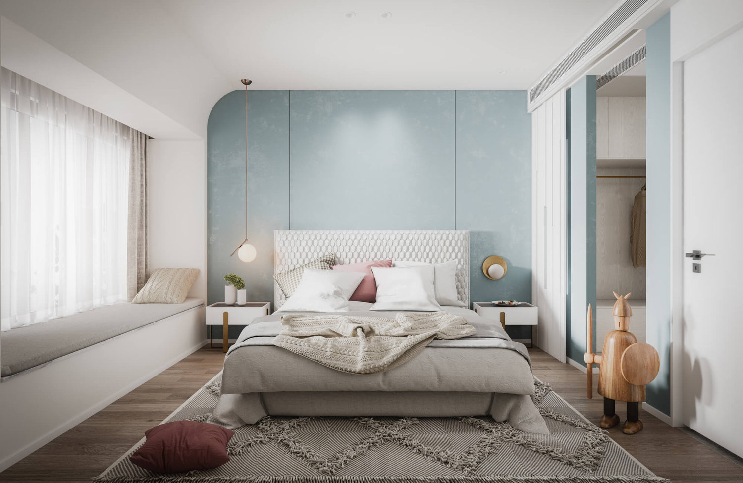 Modern bedroom with a soft blue accent wall, neutral bedding, geometric wool rug, and natural light streaming through sheer curtains.