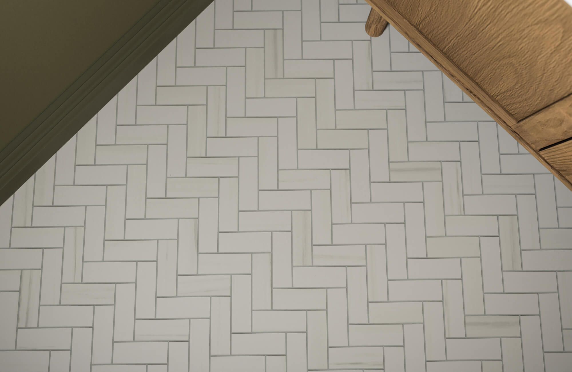 White herringbone tile floor with subtle gray veining, creating a clean and structured pattern beneath wood cabinetry.