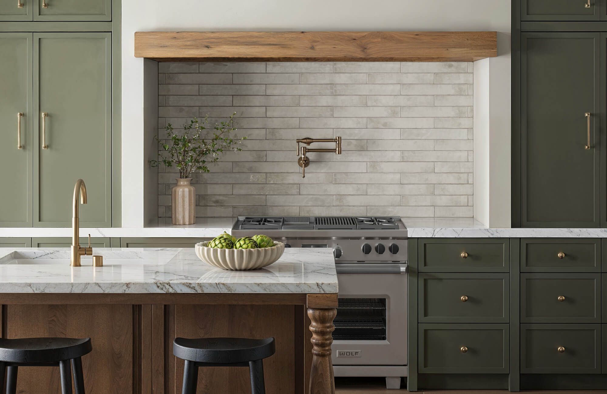 Farmhouse kitchen with long horizontal subway tile backsplash in soft gray, featuring a matte finish, green cabinetry, marble countertops, and warm wood accents.