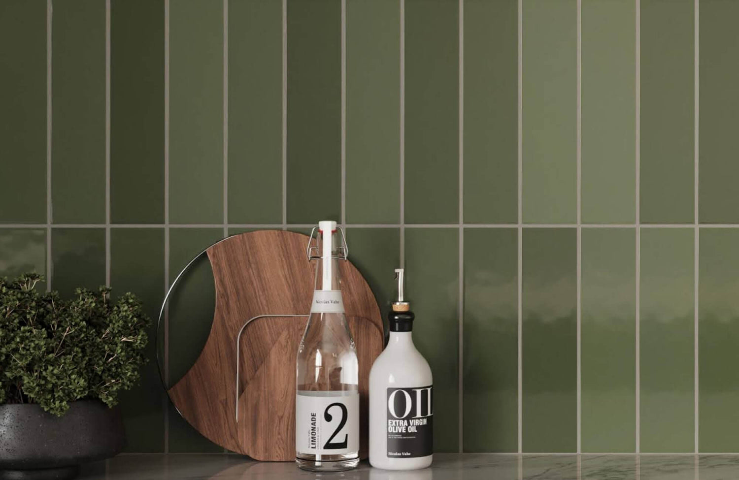 Glossy olive green vertical subway tiles with tonal variation and soft grout lines create a bold, organic backsplash.