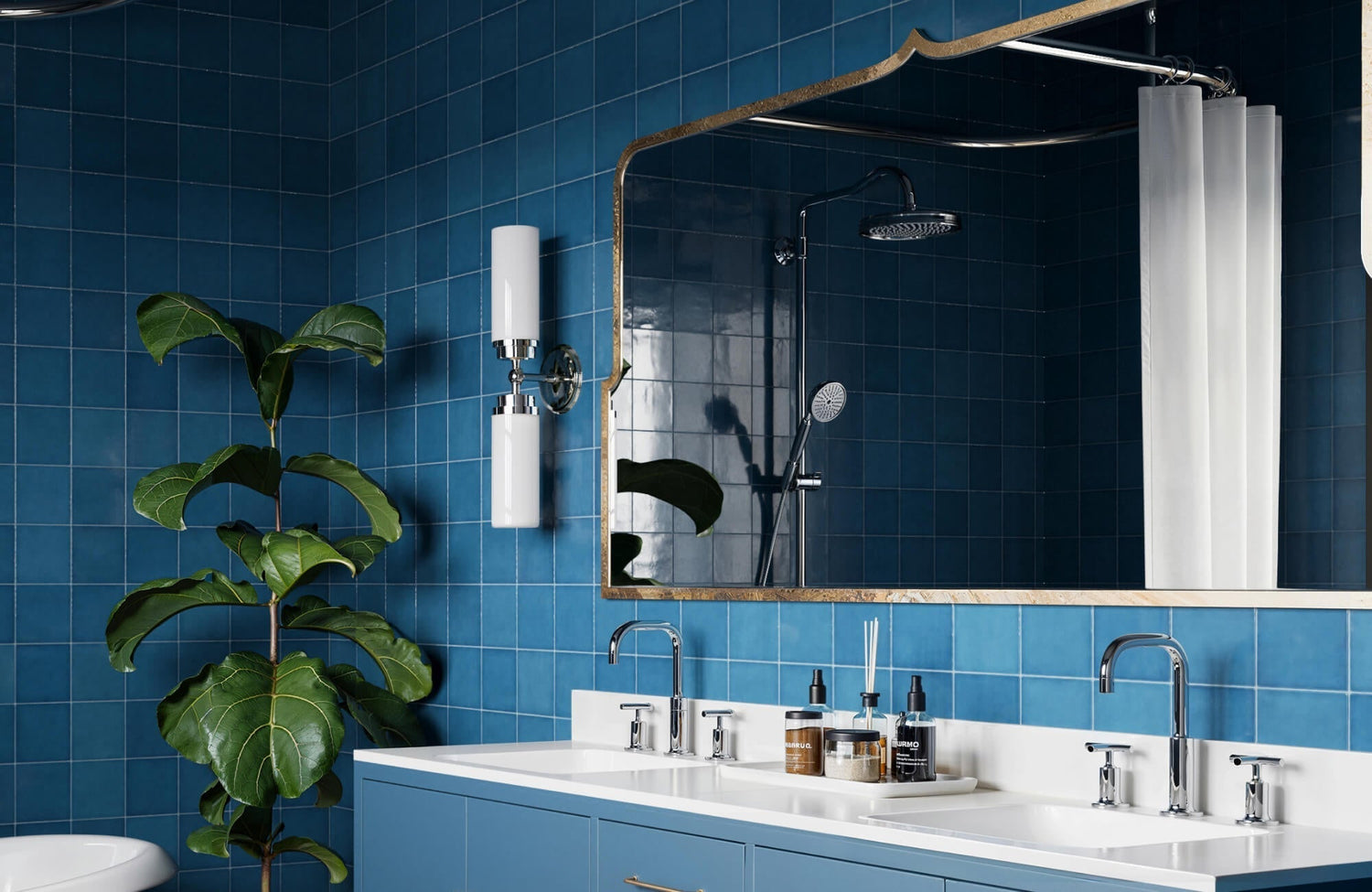 Bold blue tiled bathroom backsplash with dual sinks, polished chrome fixtures, scalloped-edge mirror, and a vibrant fiddle-leaf fig for natural contrast
