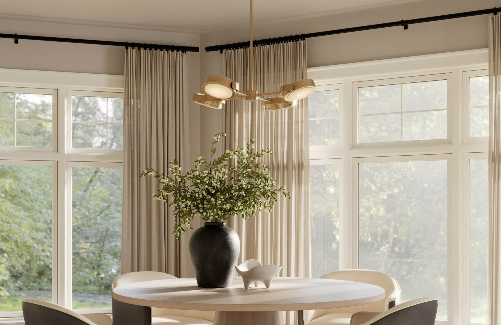 Modern dining nook with an LED gold chandelier, a round light wood table, and sheer drapery framing large grid windows.