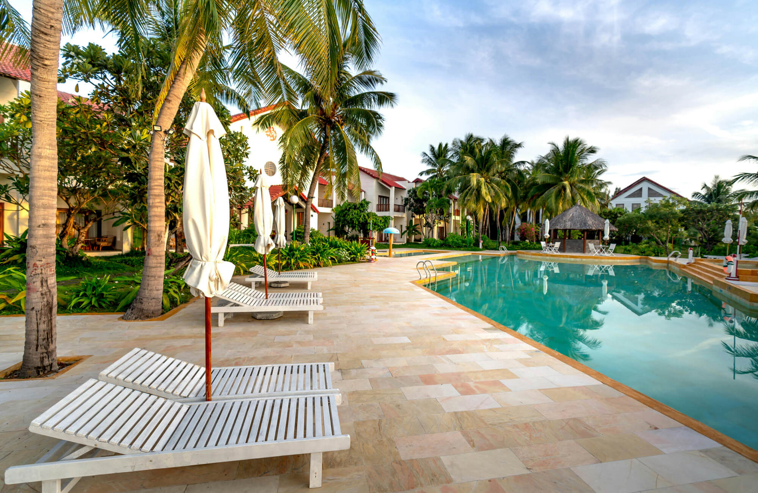 A resort-style pool surrounded by stone-look tiles showing how sealed surfaces maintain a clean, durable finish.