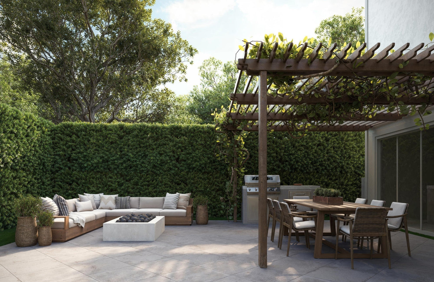 Outdoor lounge and dining area featuring large square porcelain pavers under a pergola and barbecue setup.