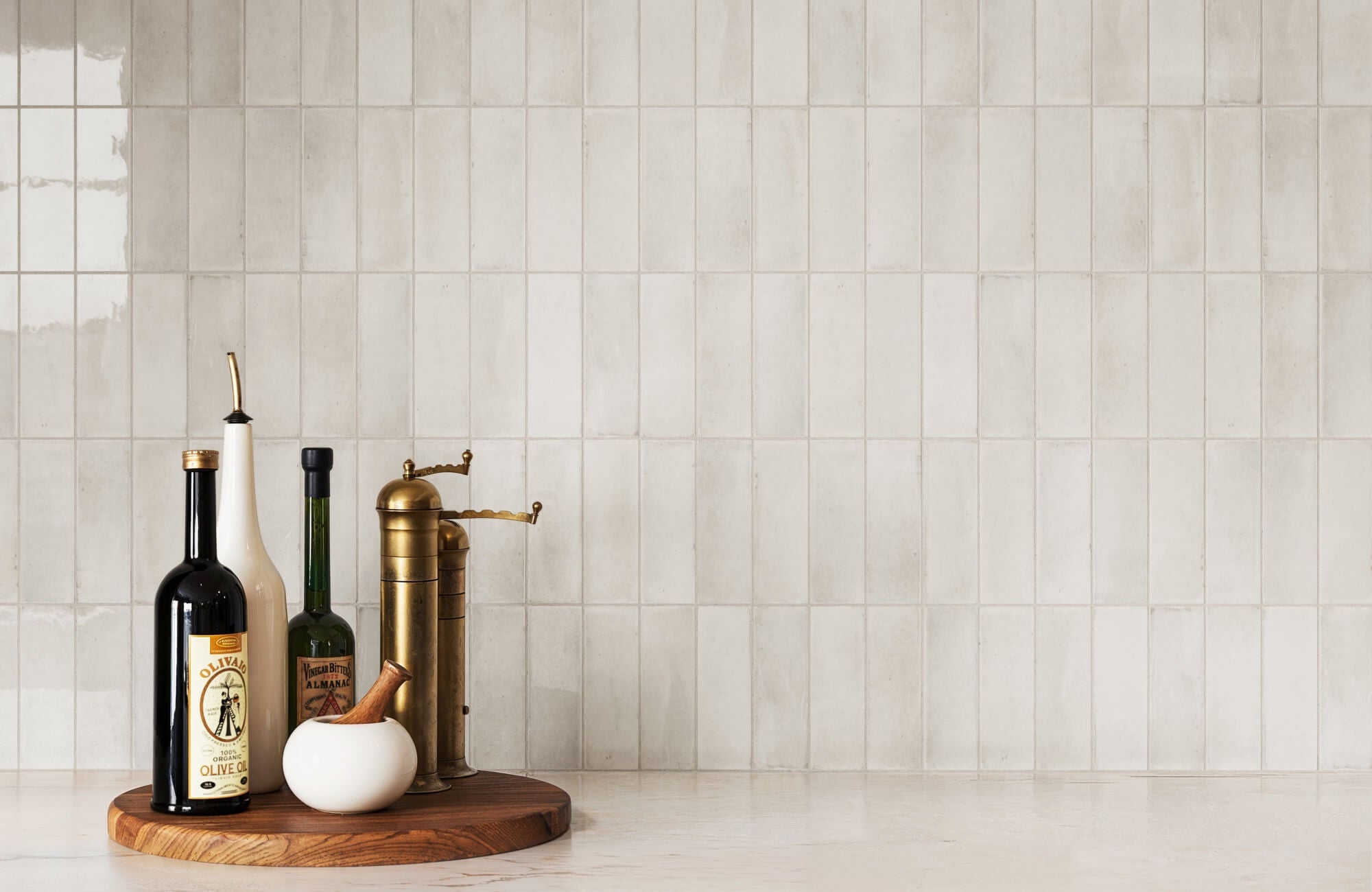 White subway tile wall backdrop behind a kitchen counter with food prep scene, showcasing a timeless backsplash style for bright and clean interiors