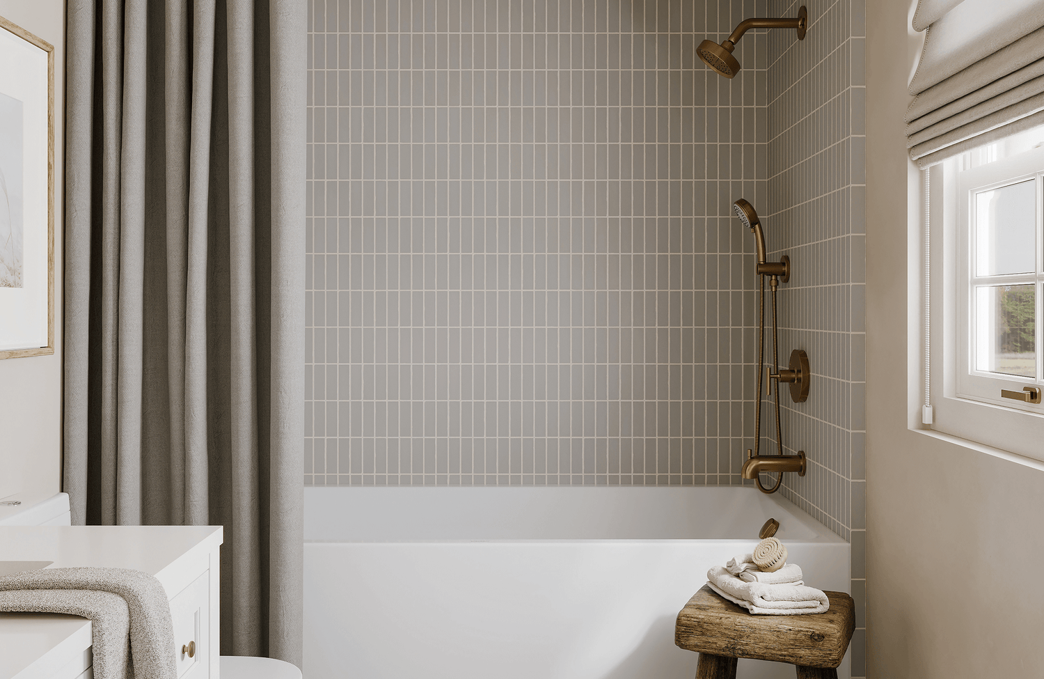Soft gray vertical subway tiles frame a serene tub-shower combo with brushed brass fixtures and neutral accents.