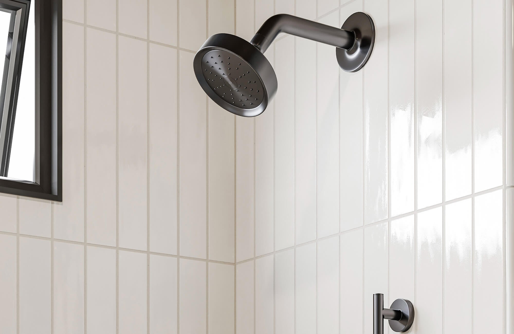 Shower wall featuring vertically stacked glossy white ceramic tiles paired with matte black fixtures for a bold and spacious modern look