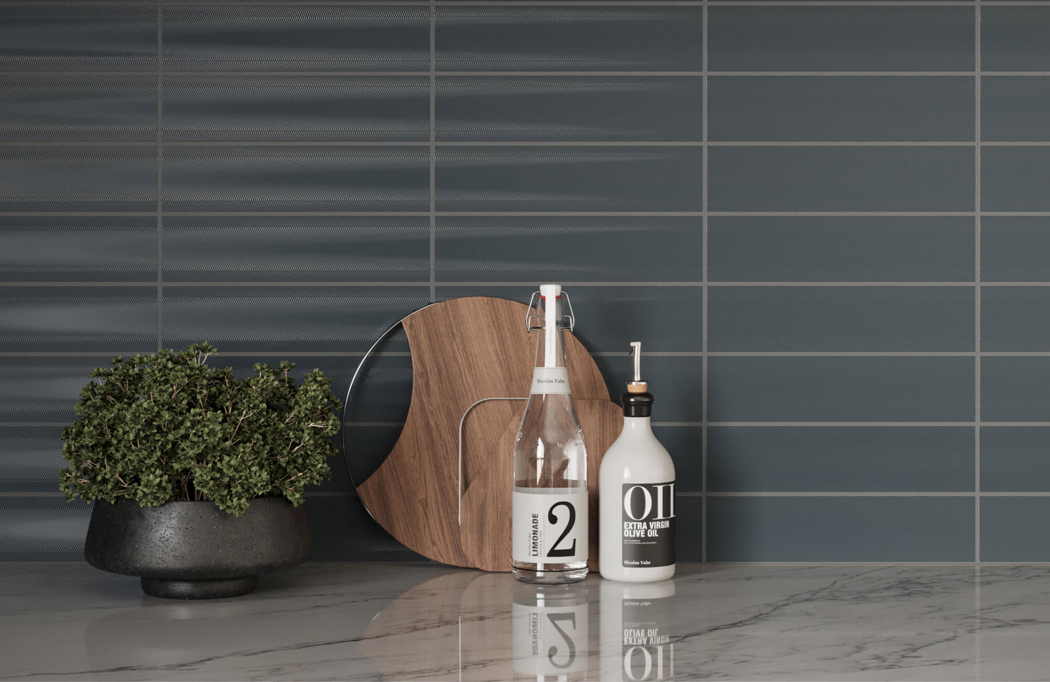 Modern kitchen countertop featuring sleek blue subway tiles with a subtle horizontal ripple texture, complemented by a potted plant, wooden board, and bottles of olive oil and lemonade.