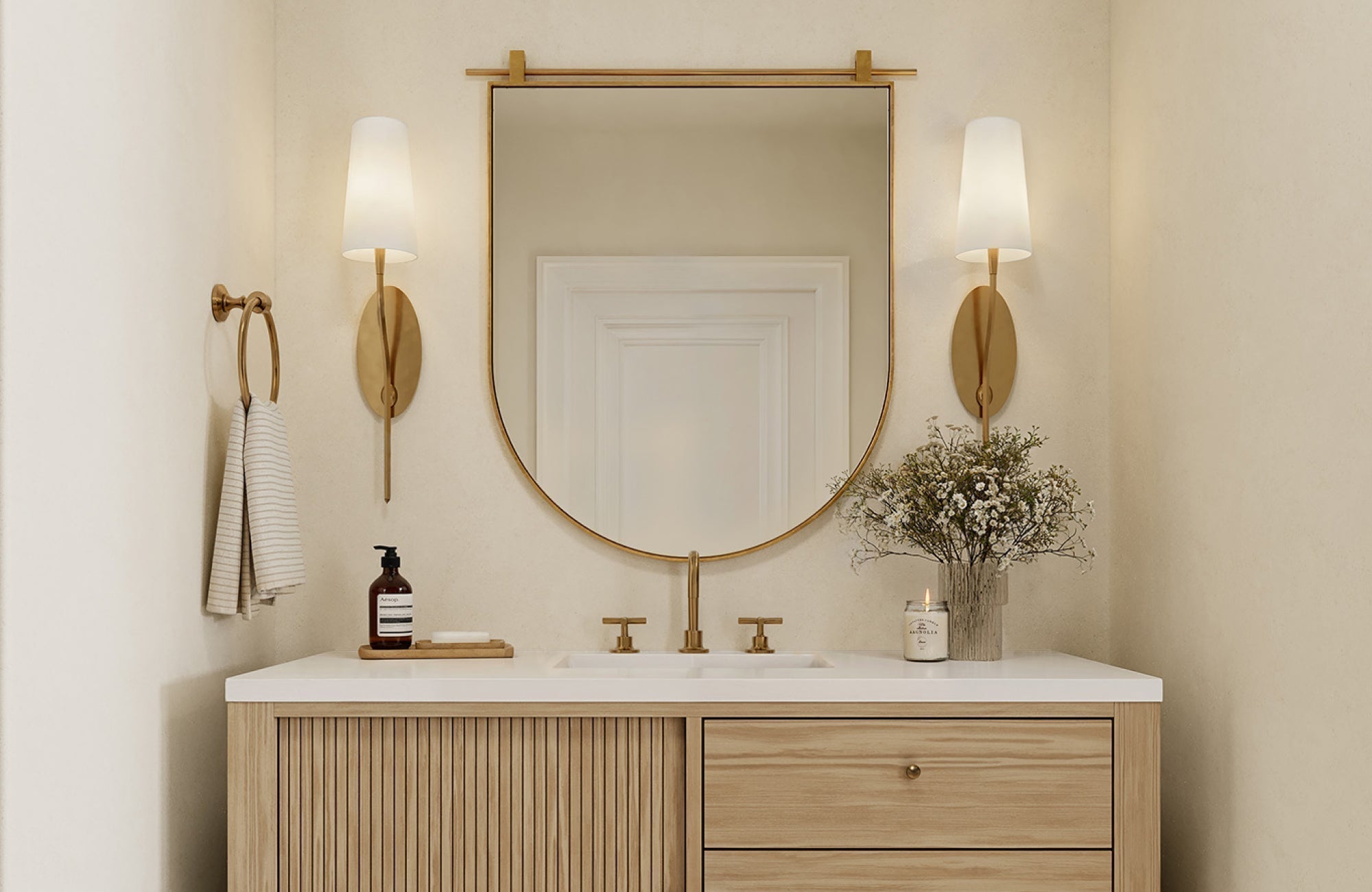 Wall sconces flanking a round mirror, sized proportionally to the vanity for balanced illumination.