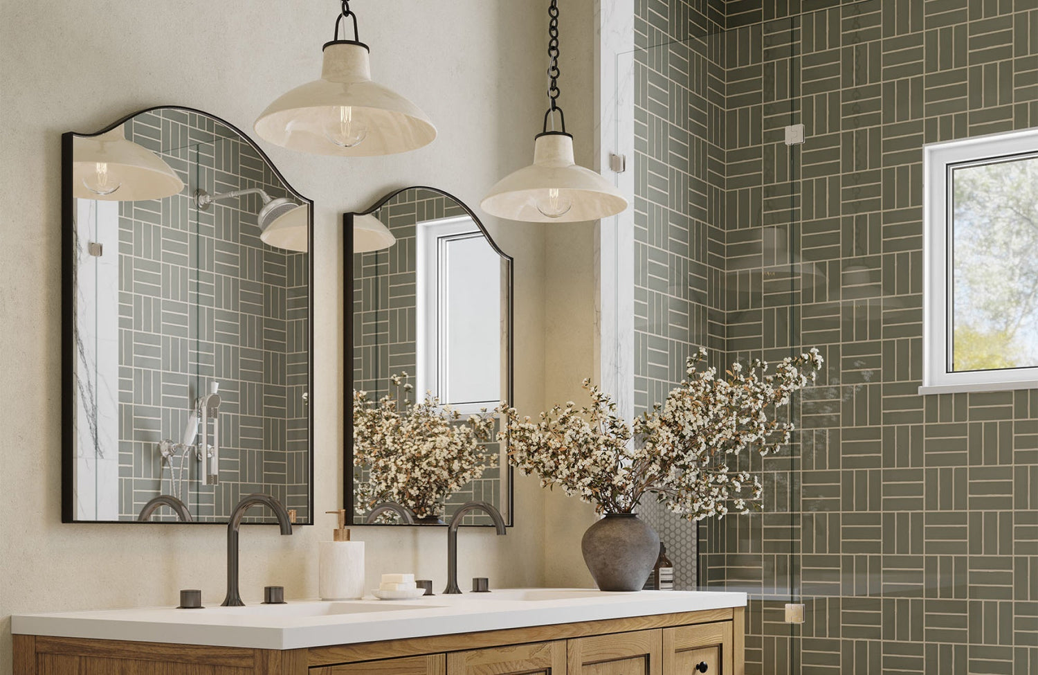 Double mirrors with arched tops over a 60-inch vanity, framed by pendant lights and accented with a tall floral arrangement.