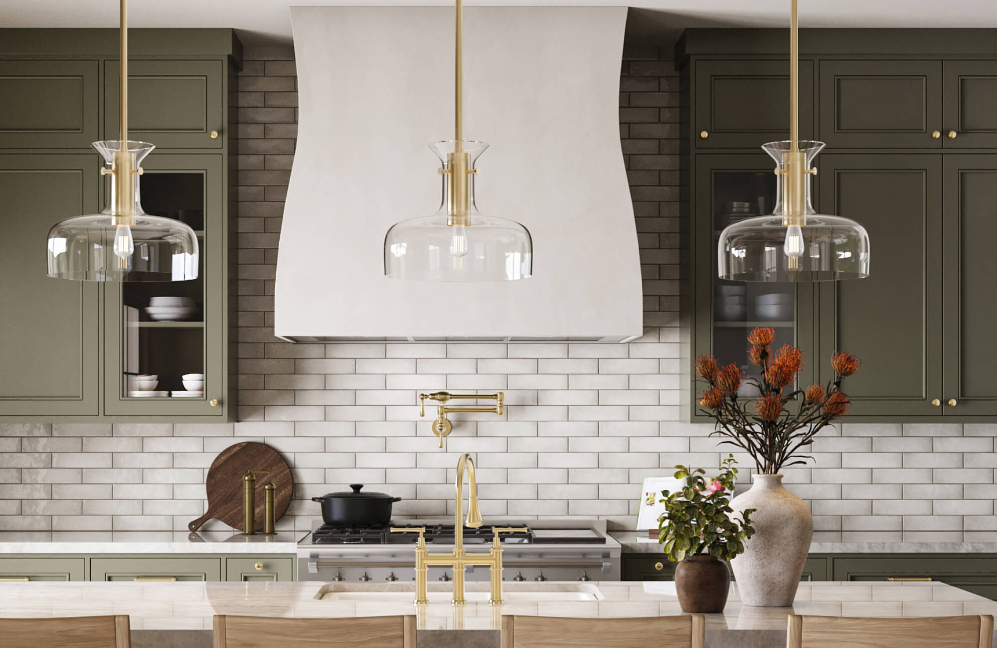 Elegant kitchen with white subway tile backsplash, sage green cabinetry, and brass fixtures beneath glass pendant lights.