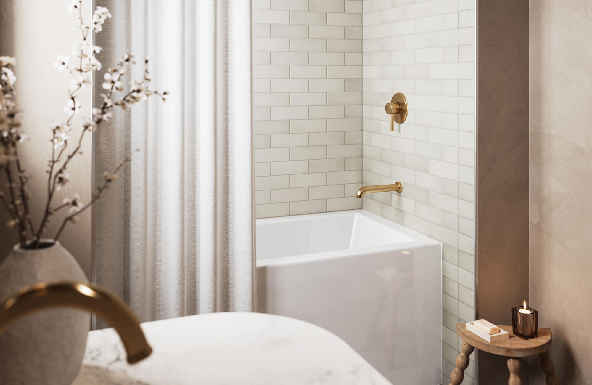 Small classy bathroom with white subway tile shower walls, brass fixtures, and soft neutral decor creating a clean and elegant space.