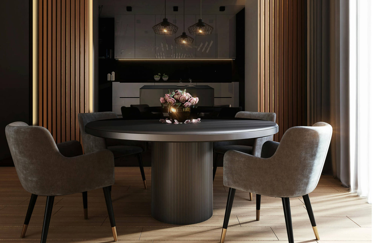A modern dining room set featuring a round matte-black pedestal table, plush taupe upholstered chairs with gold-tipped legs, and a soft, moody backdrop creates an elegant, warmly lit space anchored by a sculptural floral centerpiece.