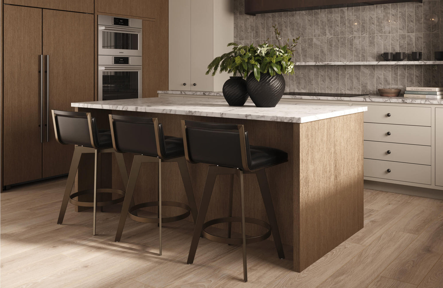 Modern kitchen island with marble countertop, brown wood paneling, and three black leather stools.