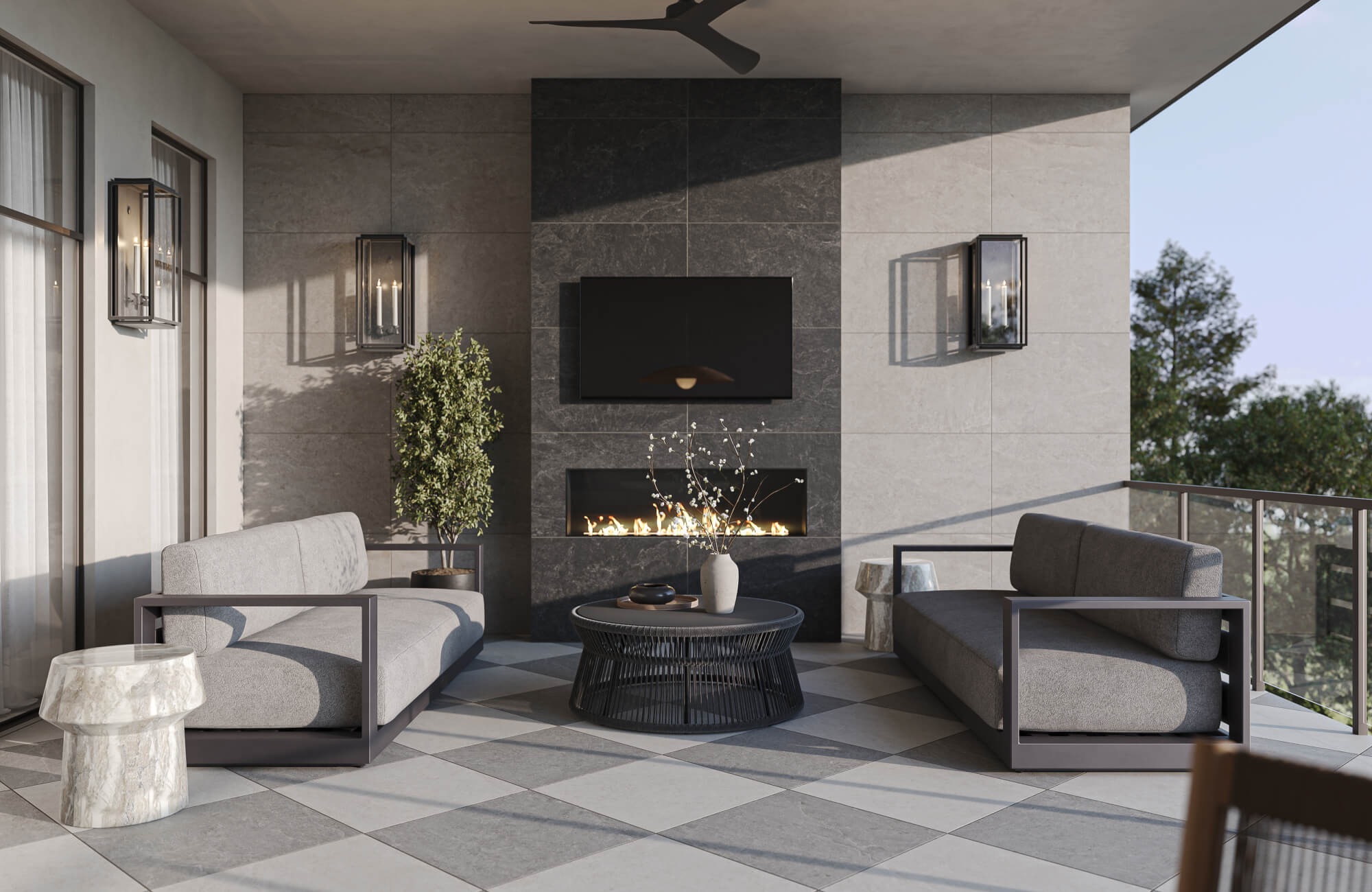 Modern outdoor furniture with gray sofas and a black metal frame, paired with a stone fireplace and light gray tile flooring for a clean, durable setup.
