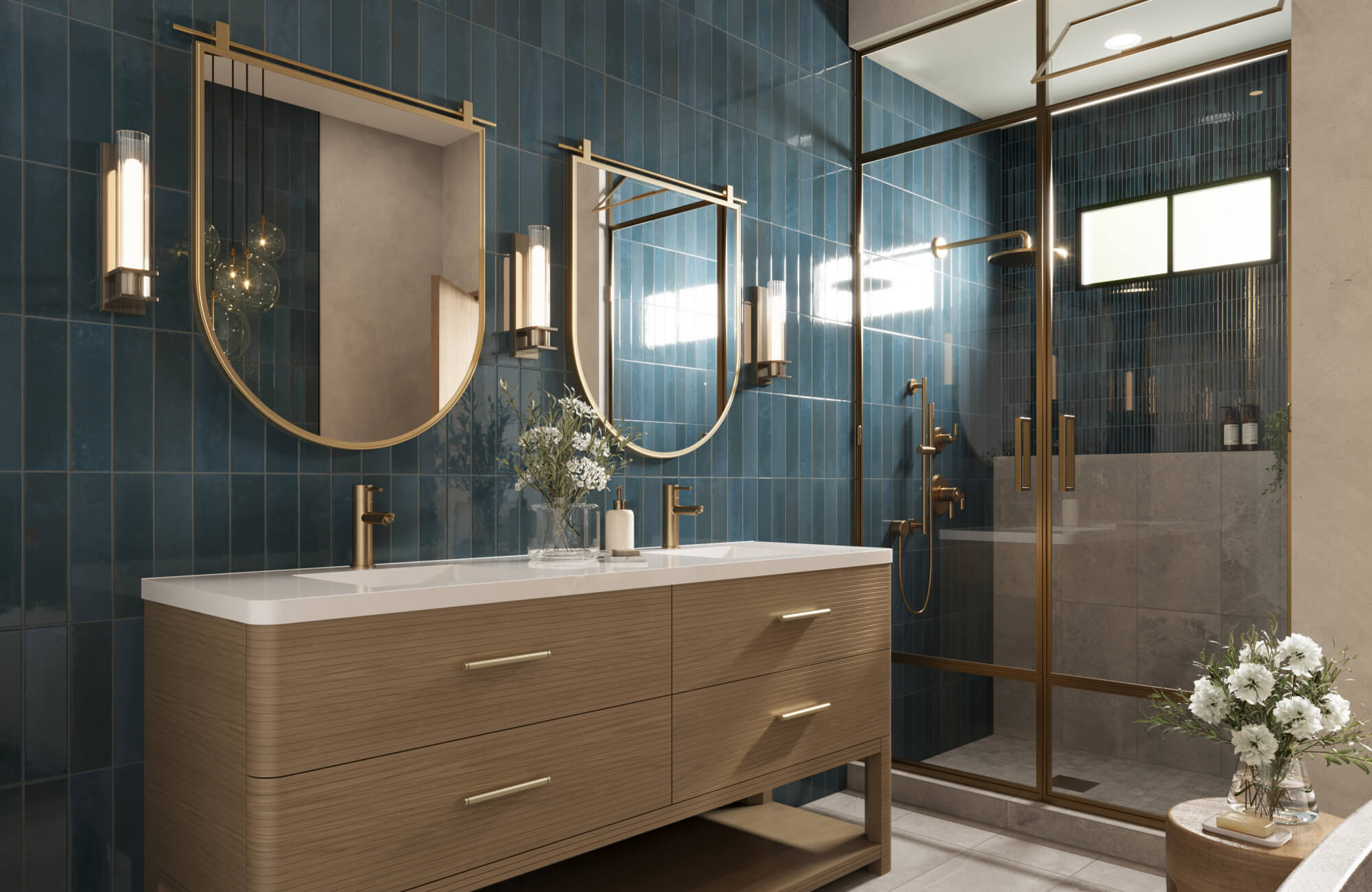Chic bathroom with glossy vertical blue tiles, brass fixtures, rounded-edge wood vanity, and dual half-arch mirrors.