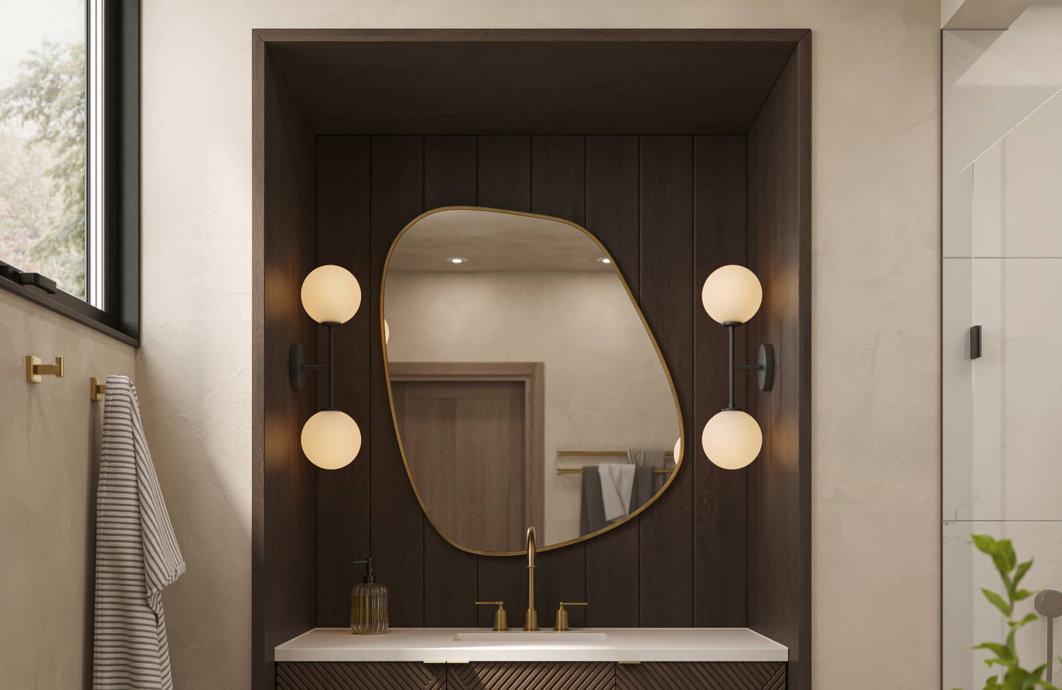 Contemporary bathroom featuring black vanity lights mounted on a dark wood panel, highlighting an asymmetrical mirror, warm brass fixtures, and a clean white countertop.