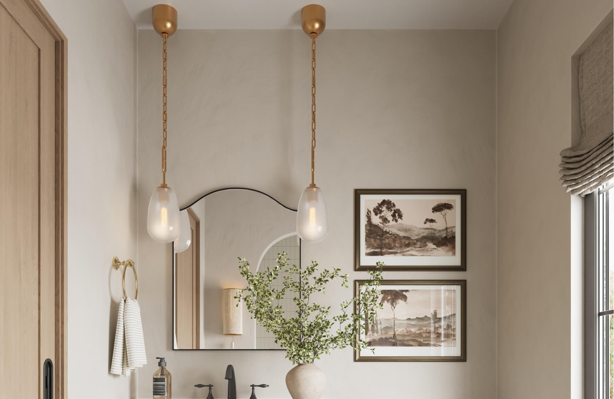 Elegant bathroom with sculptural pendant lights, arched mirror, matte black faucet, and neutral tones accented by framed art.