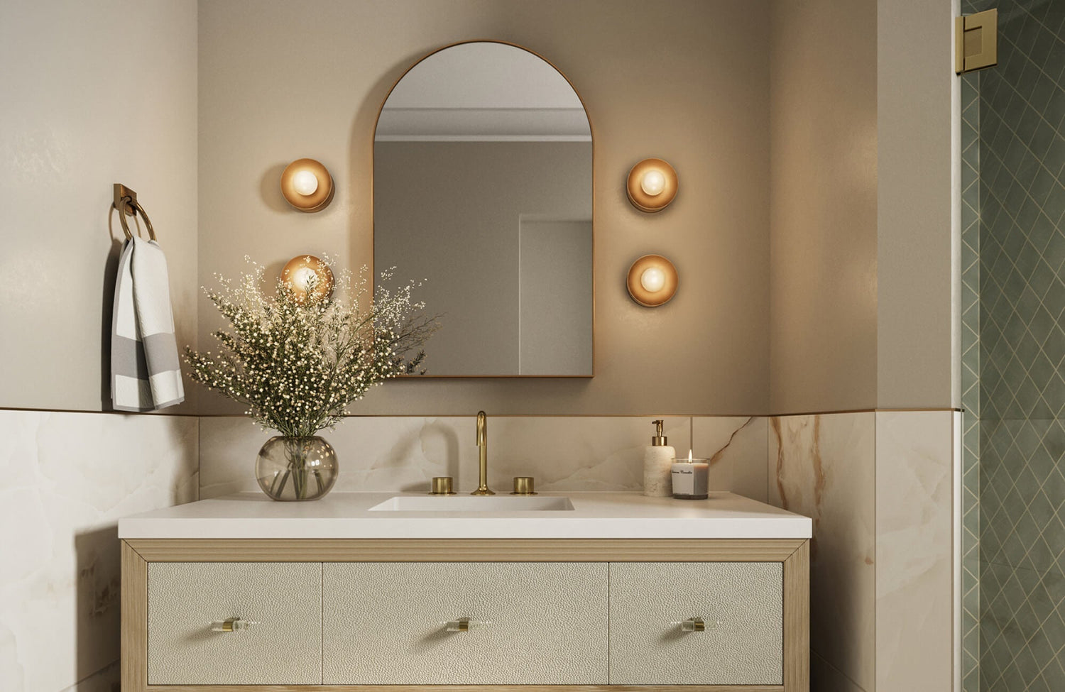 Elegant bathroom with a textured cream vanity, arched mirror, and warm globe wall sconces arranged in a vertical trio.