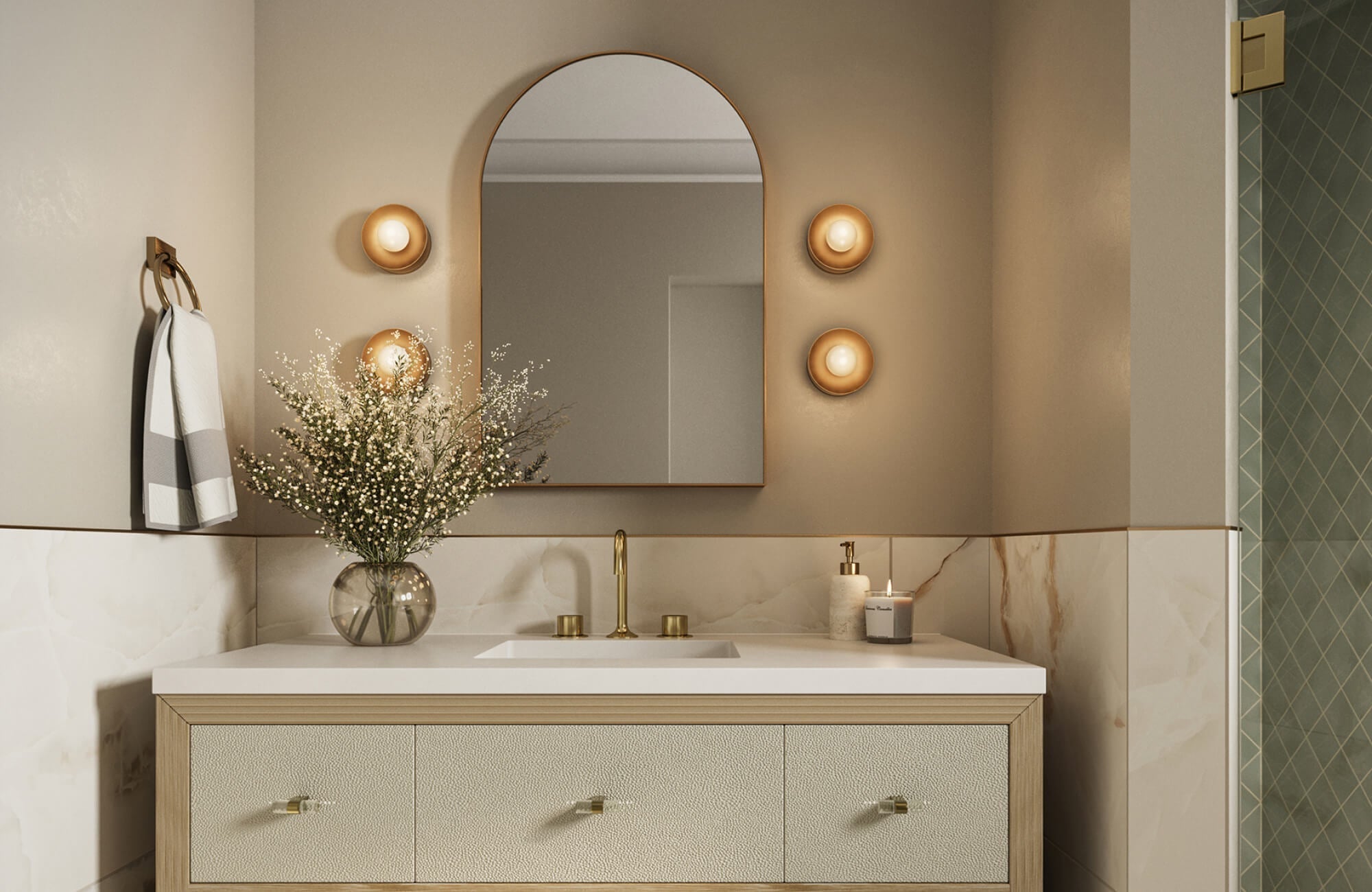 Elegant bathroom with a textured cream vanity, arched mirror, and warm globe wall sconces arranged in a vertical trio.
