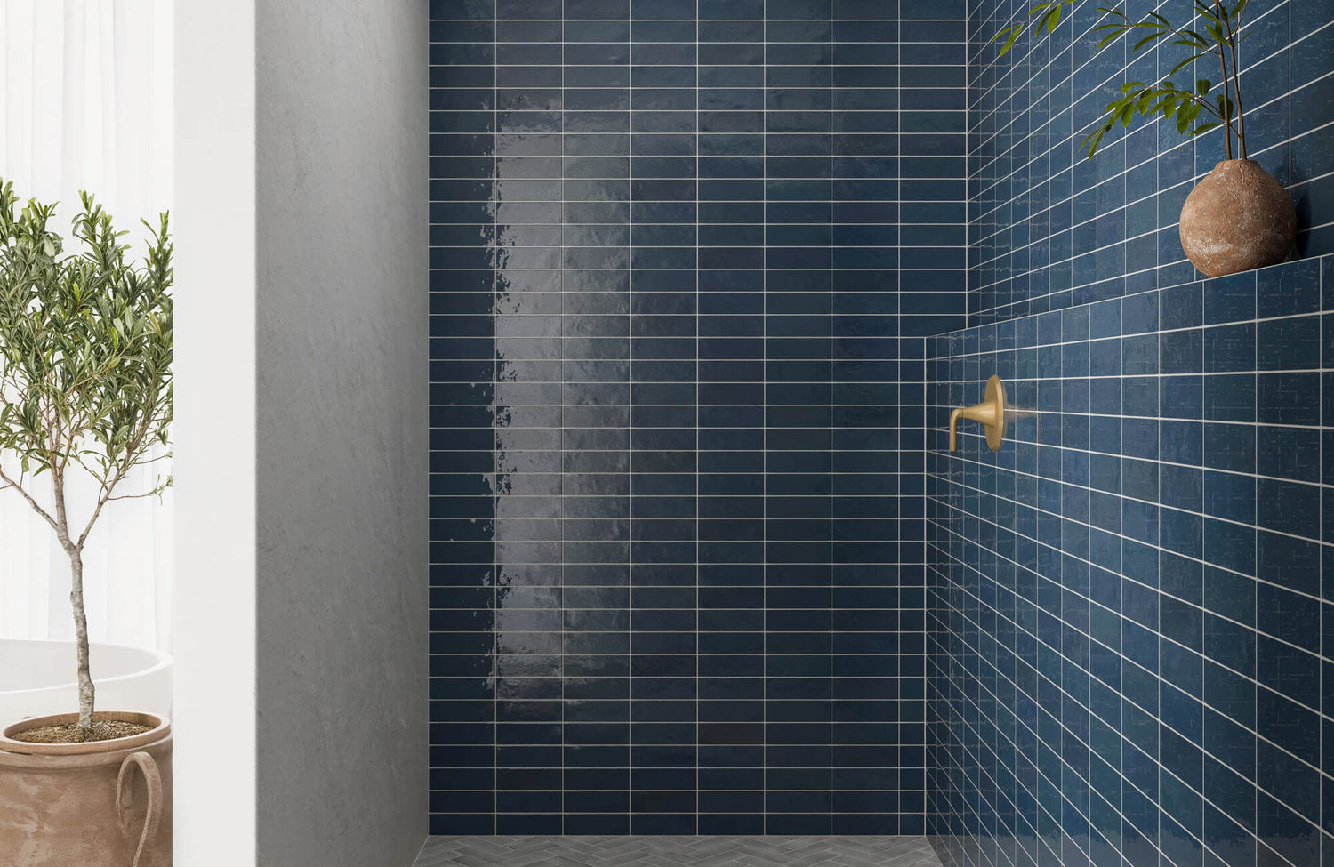 Sleek blue ceramic tiles with a glossy finish line a minimalist walk-in shower, accented by a matte brass shower fixture.