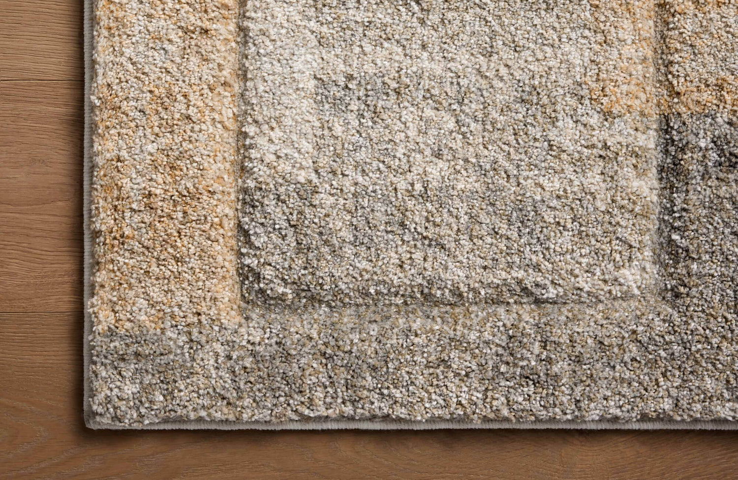 A close-up of a polypropylene rug highlights its dense, textured pile and subtle beige, gray, and brown tones, showcasing the durability that helps polypropylene rugs last.