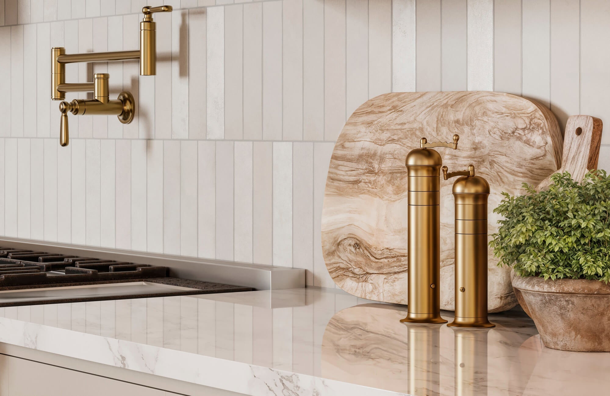 Vertical white subway tile backsplash in a modern kitchen with gold pot filler, marble countertop, and brass spice grinders.