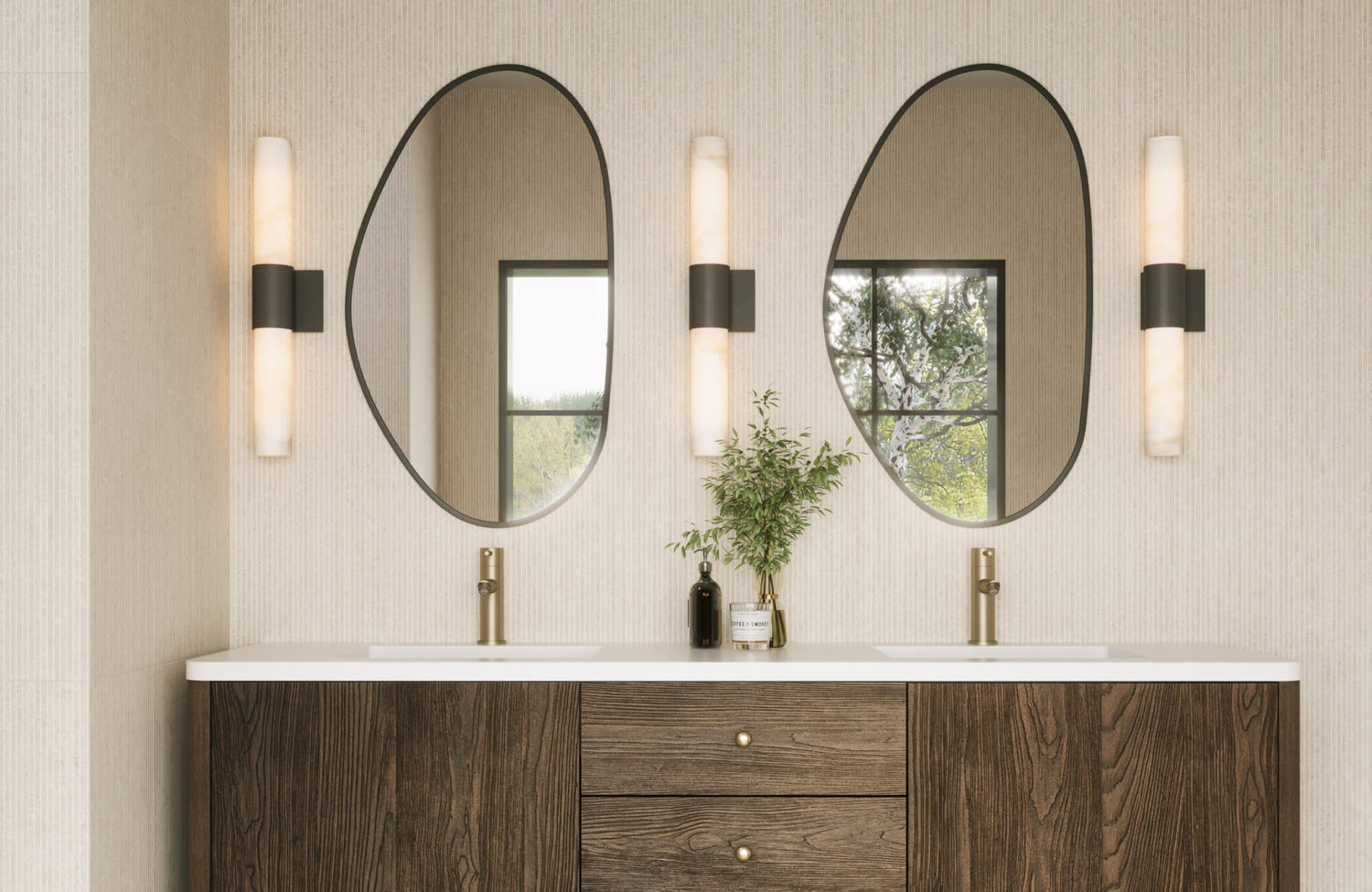 Double vanity with asymmetrical mirrors, alabaster sconces, and rich wood cabinetry against a textured wall.
