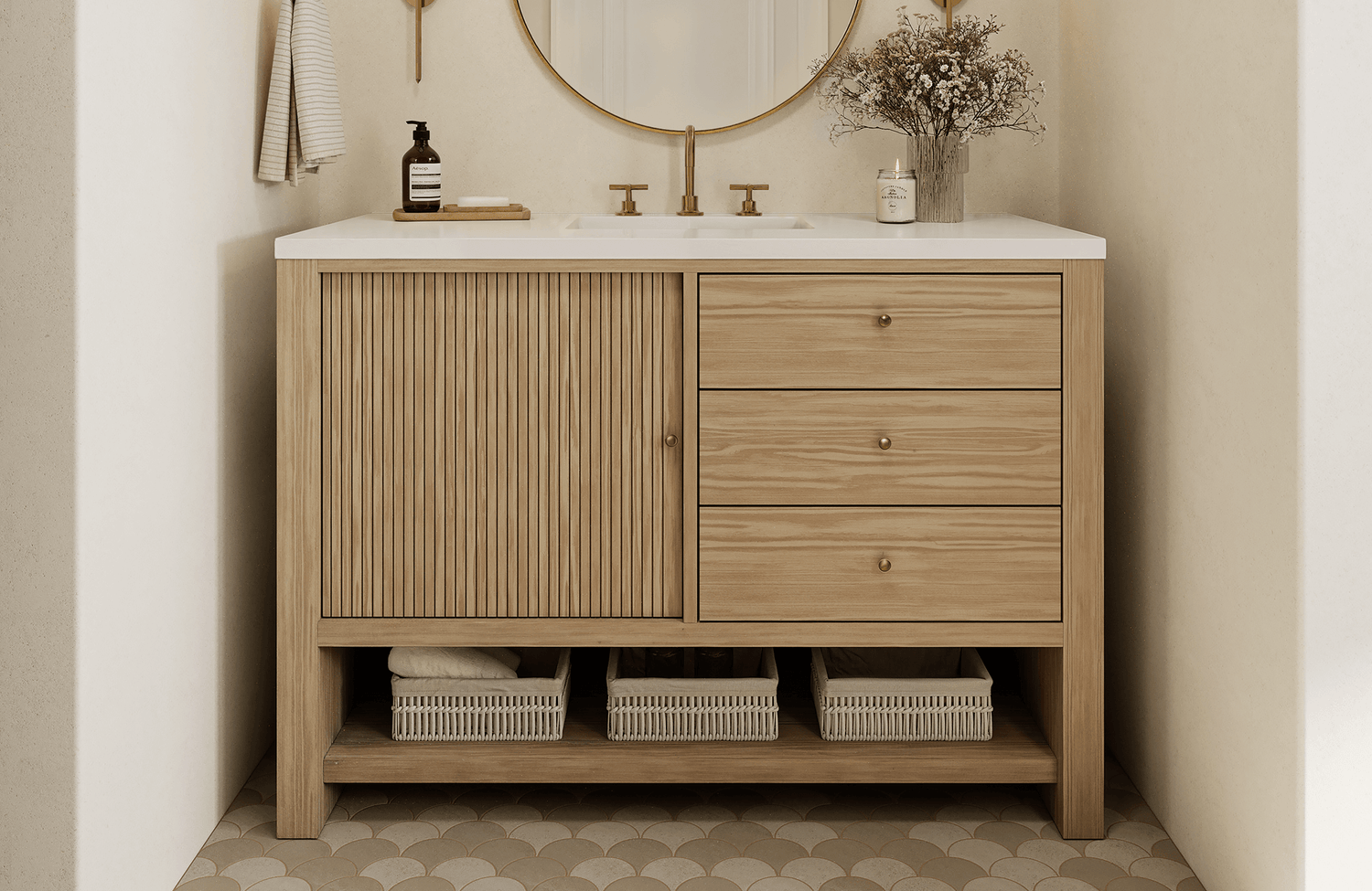 Bathroom vanity with light wood cabinet, round mirror, and traditional scalloped floor tiles.