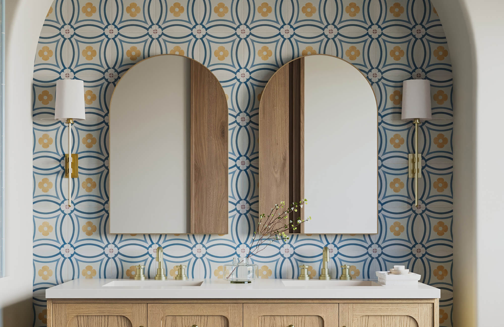 Stylish bathroom with patterned ceramic tile backsplash, matching twin mirrors, and a wood vanity with curved detailing and gold hardware.